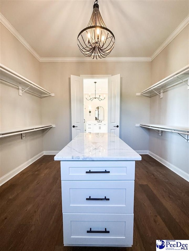 walk in closet featuring dark wood-type flooring and an inviting chandelier