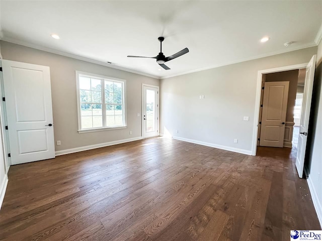 empty room featuring baseboards, dark wood finished floors, and crown molding