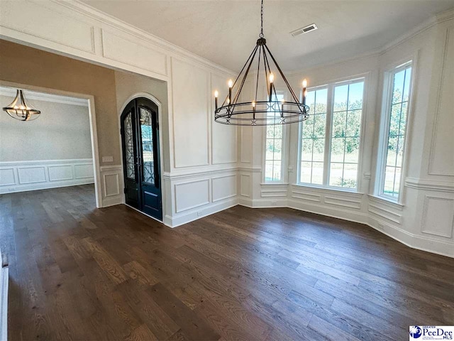 unfurnished dining area with a wealth of natural light, arched walkways, visible vents, and a decorative wall