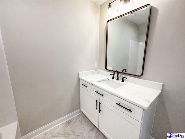 bathroom featuring marble finish floor, vanity, and baseboards