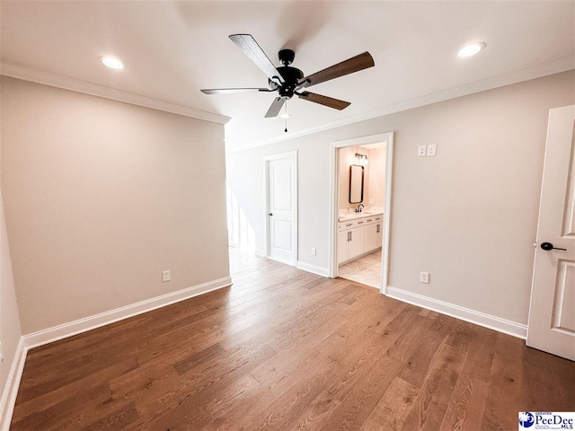 unfurnished bedroom with crown molding, baseboards, and wood finished floors