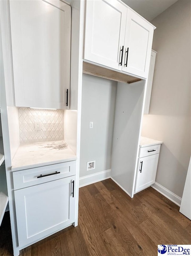 laundry room with dark wood-type flooring and baseboards