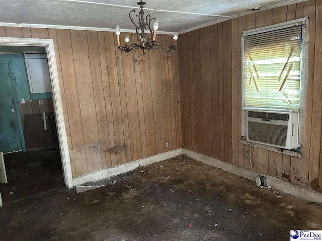 unfurnished dining area with baseboards, cooling unit, wooden walls, and a chandelier