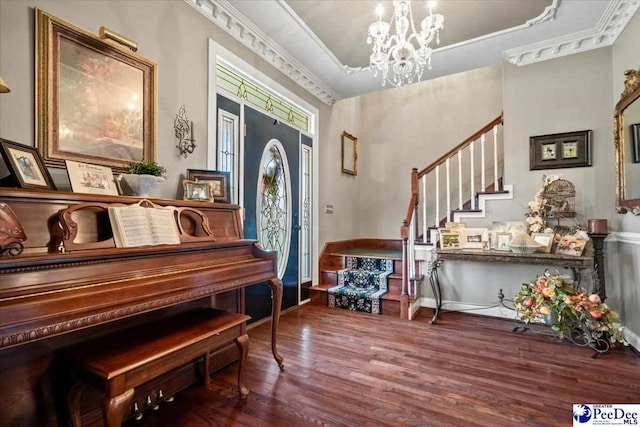 miscellaneous room with hardwood / wood-style flooring, ornamental molding, and a notable chandelier