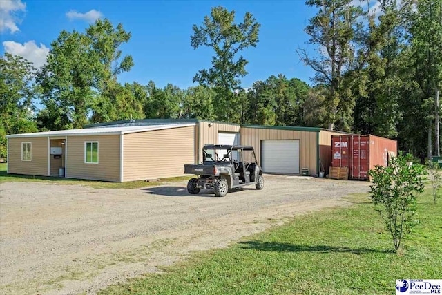 exterior space featuring an outbuilding, a garage, and a front yard