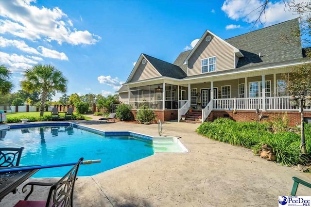 view of pool with a patio and a sunroom