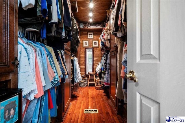 spacious closet with dark hardwood / wood-style flooring