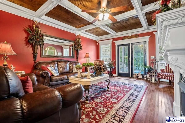 living room featuring ceiling fan, hardwood / wood-style floors, coffered ceiling, ornamental molding, and wooden ceiling