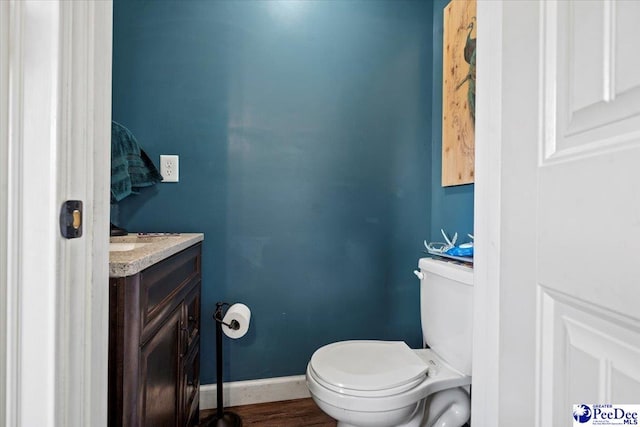 bathroom with vanity, hardwood / wood-style flooring, and toilet