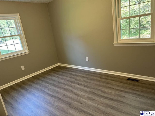 unfurnished room featuring dark hardwood / wood-style flooring