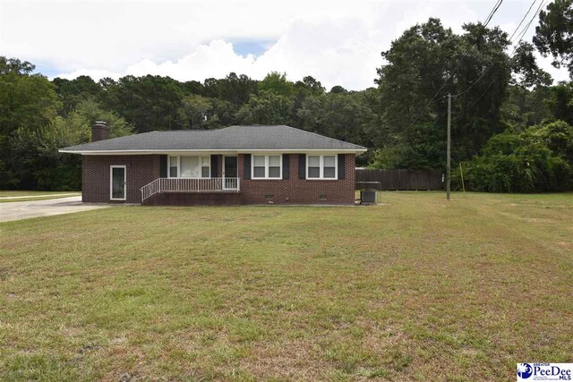 ranch-style house featuring central AC, covered porch, and a front lawn