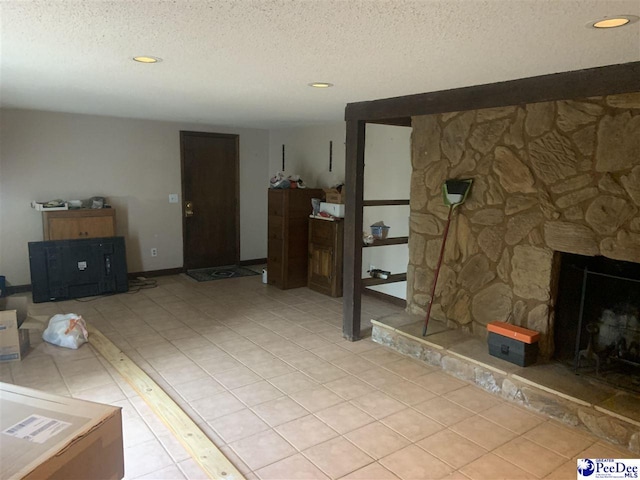 unfurnished living room with light tile patterned flooring, a stone fireplace, recessed lighting, and a textured ceiling