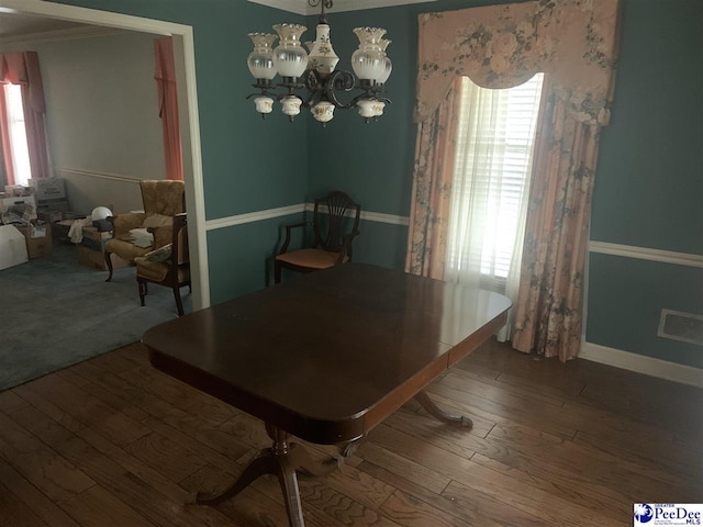 dining space with hardwood / wood-style floors, baseboards, visible vents, and a notable chandelier
