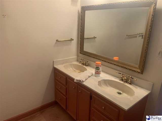 bathroom featuring baseboards, double vanity, and a sink