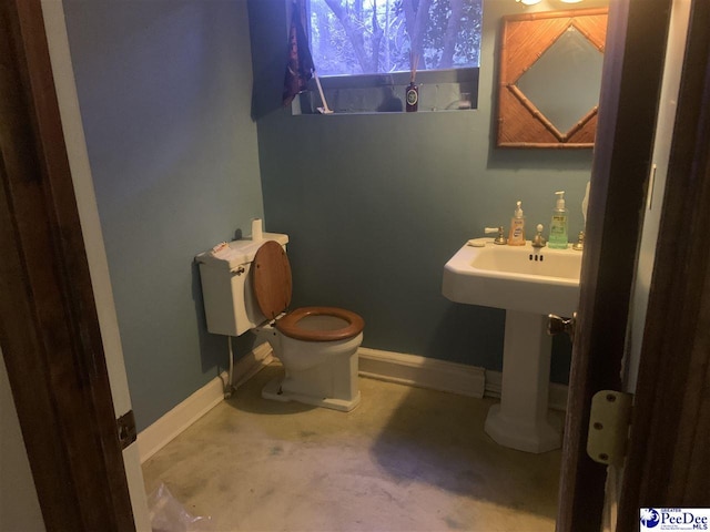 half bath featuring toilet and baseboards