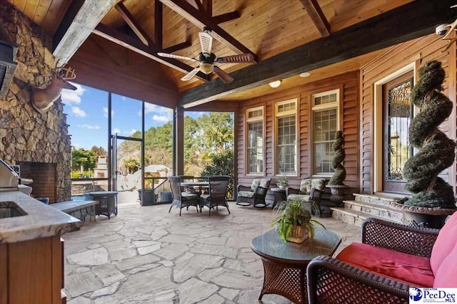 sunroom featuring vaulted ceiling with beams, ceiling fan, and wooden ceiling