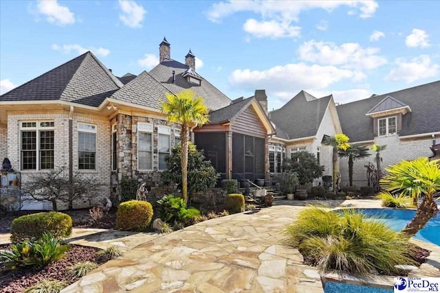 view of front of house featuring a sunroom and a patio area