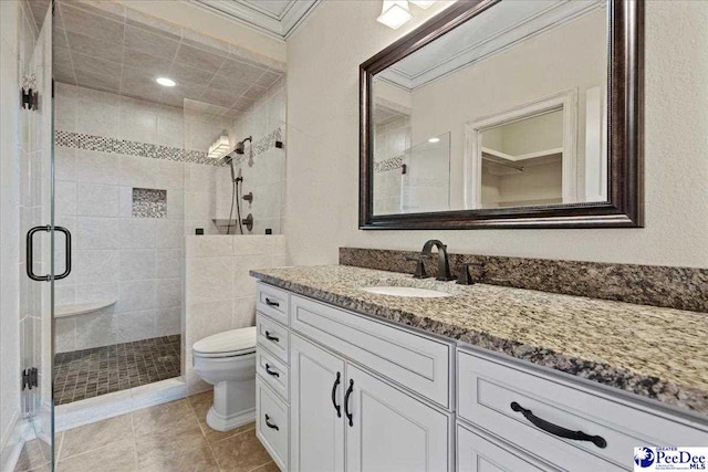 bathroom featuring tile patterned flooring, vanity, an enclosed shower, toilet, and crown molding