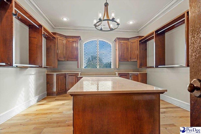 kitchen featuring hanging light fixtures, ornamental molding, a chandelier, and light hardwood / wood-style floors