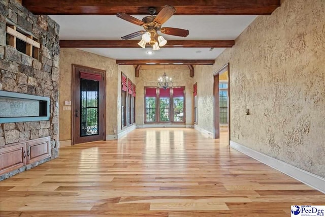 unfurnished living room featuring ceiling fan with notable chandelier, beam ceiling, and light hardwood / wood-style flooring