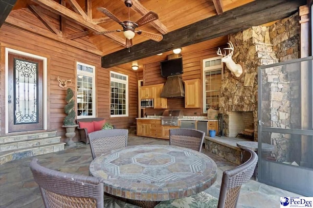 view of patio featuring ceiling fan, grilling area, area for grilling, and an outdoor stone fireplace