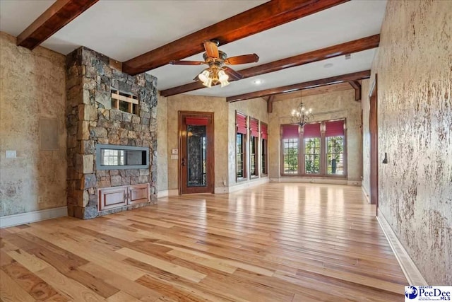 unfurnished living room with a stone fireplace, ceiling fan with notable chandelier, beamed ceiling, and light wood-type flooring