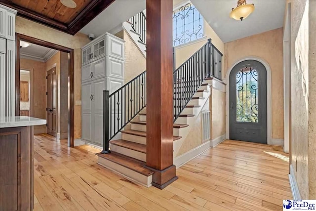 foyer featuring crown molding and light hardwood / wood-style floors