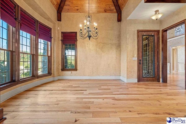 unfurnished dining area with high vaulted ceiling, light hardwood / wood-style floors, a chandelier, and beamed ceiling