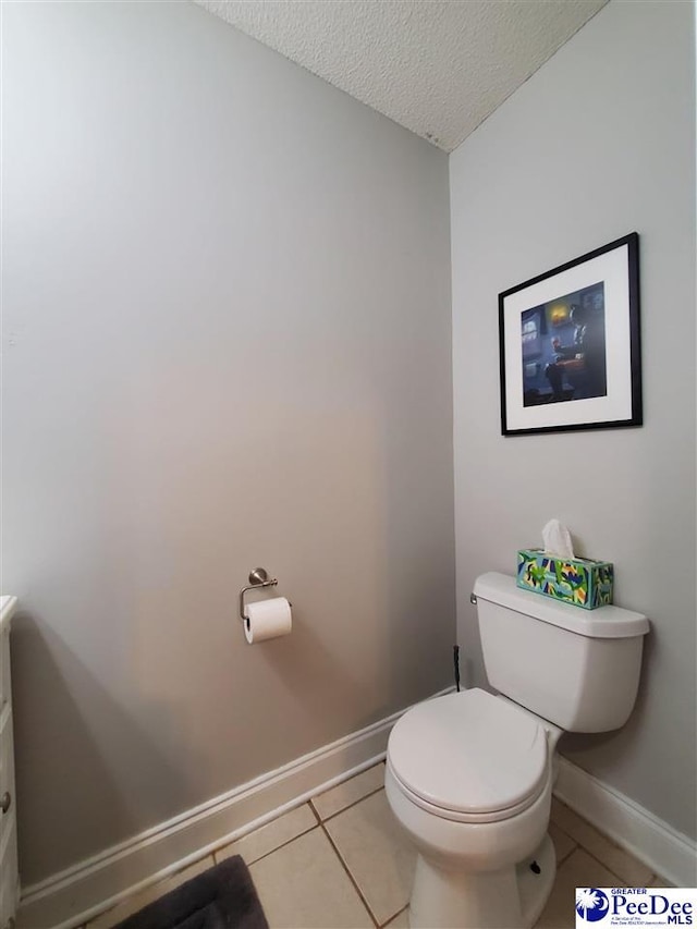 bathroom featuring tile patterned flooring, a textured ceiling, and toilet