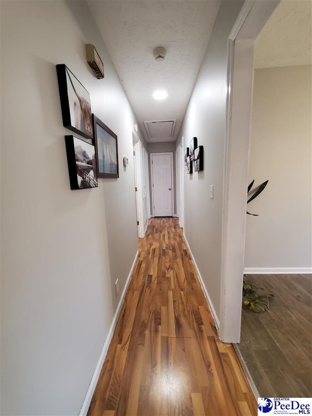 corridor featuring hardwood / wood-style floors and a textured ceiling