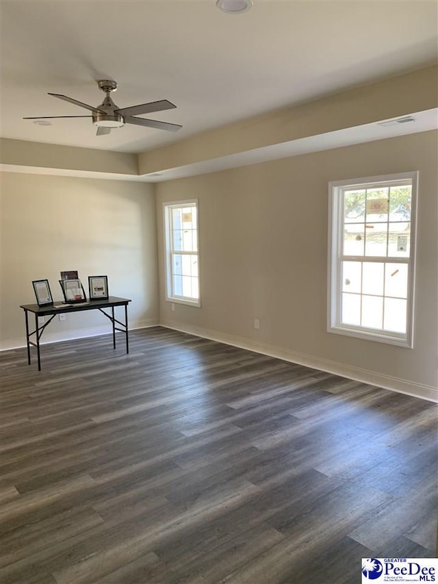 spare room with visible vents, baseboards, dark wood finished floors, and a ceiling fan