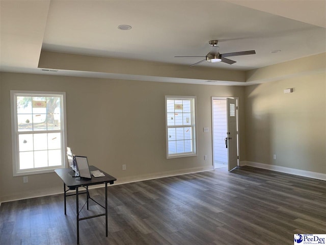 unfurnished office featuring dark wood finished floors, ceiling fan, and baseboards