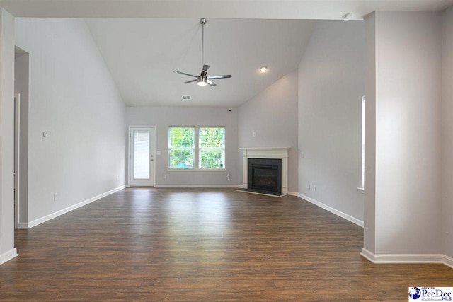 unfurnished living room with ceiling fan, vaulted ceiling, baseboards, a fireplace with raised hearth, and dark wood-style floors