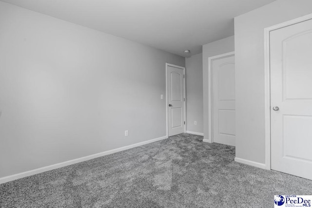 unfurnished bedroom with baseboards and carpet