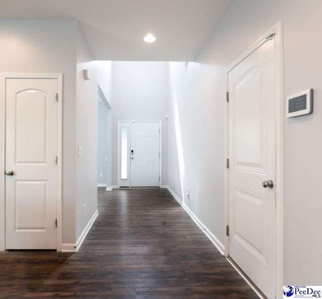 hall with baseboards, recessed lighting, and dark wood-type flooring