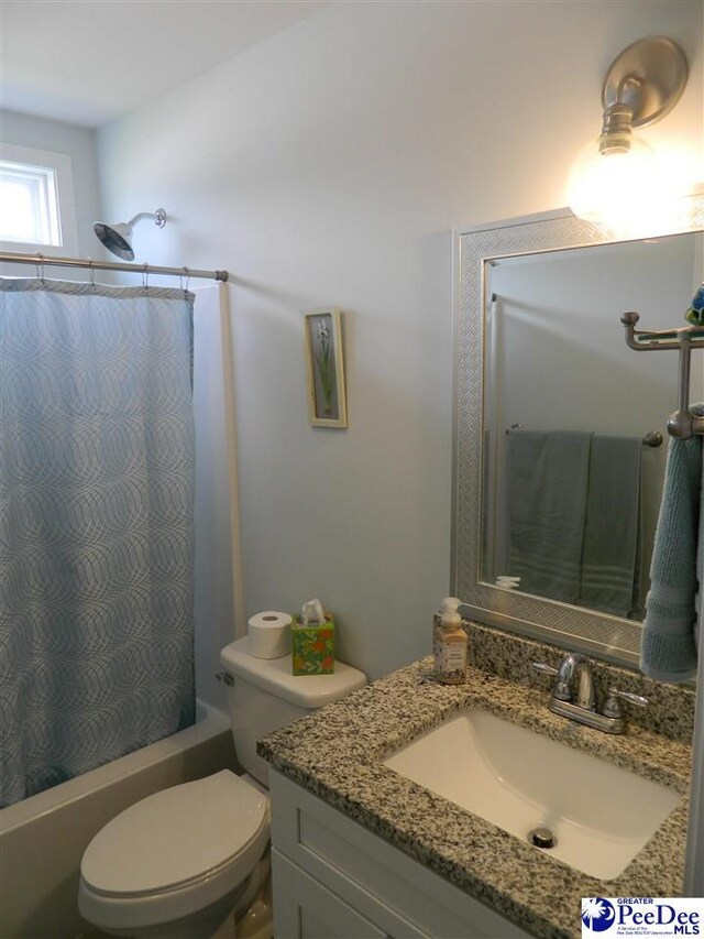 bathroom with toilet, vanity, and shower / bathtub combination with curtain