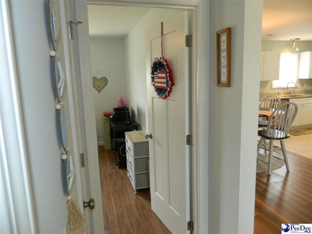 hall with dark wood-type flooring and a sink