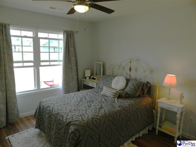 bedroom featuring wood finished floors, visible vents, baseboards, and ceiling fan