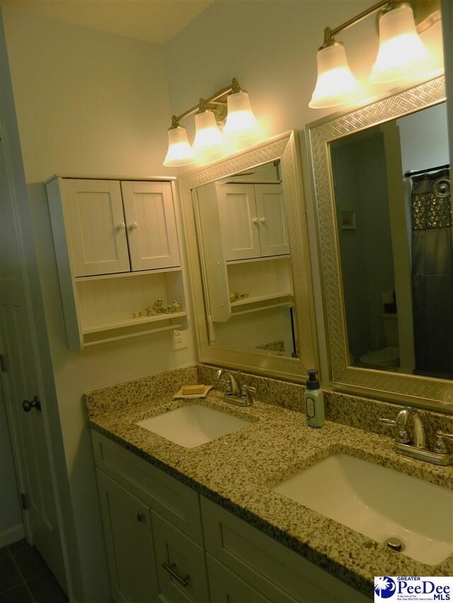 bathroom featuring double vanity, tile patterned floors, and a sink