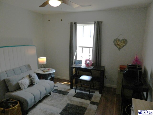 living area featuring ceiling fan, baseboards, wood finished floors, and visible vents