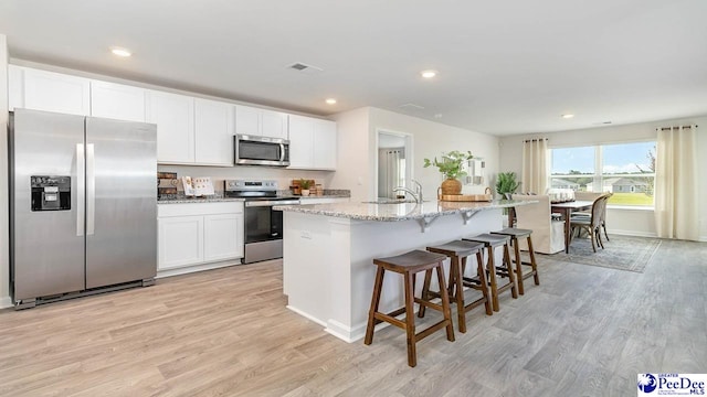 kitchen with a sink, visible vents, light wood-type flooring, and appliances with stainless steel finishes