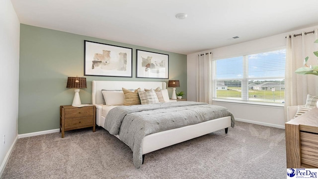bedroom with light carpet and baseboards
