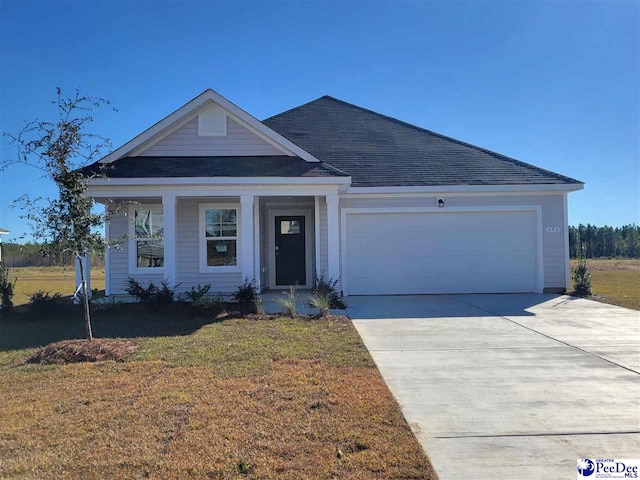 view of front of home featuring a shingled roof, driveway, a garage, and a front lawn