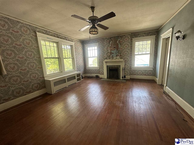 unfurnished living room featuring hardwood / wood-style flooring, ornamental molding, radiator heating unit, and ceiling fan