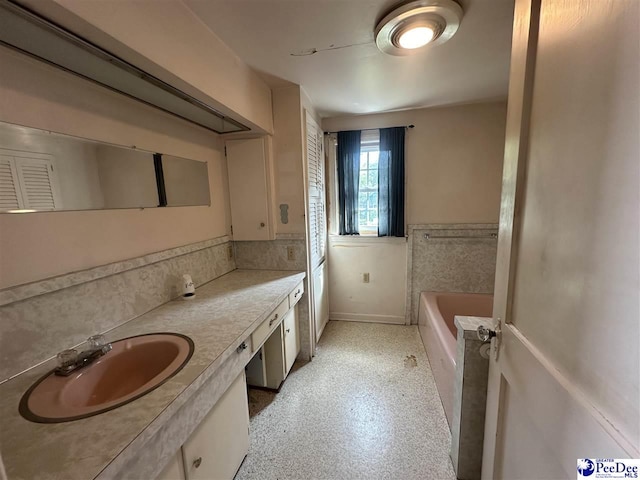 bathroom featuring vanity and a tub to relax in