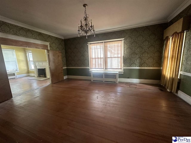 unfurnished dining area with a notable chandelier, hardwood / wood-style flooring, and ornamental molding