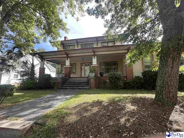 view of front of property with covered porch and a front lawn