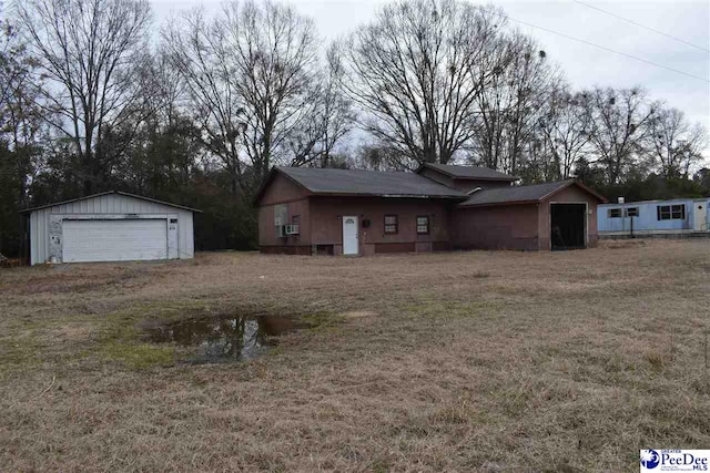 view of front of house featuring cooling unit, a garage, and a front yard