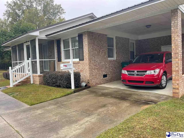 view of front of property with a front yard, a sunroom, and a carport