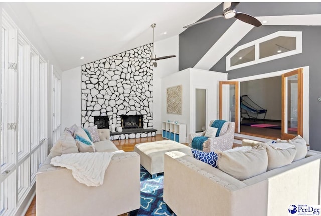 living room with hardwood / wood-style flooring, high vaulted ceiling, a fireplace, and ceiling fan
